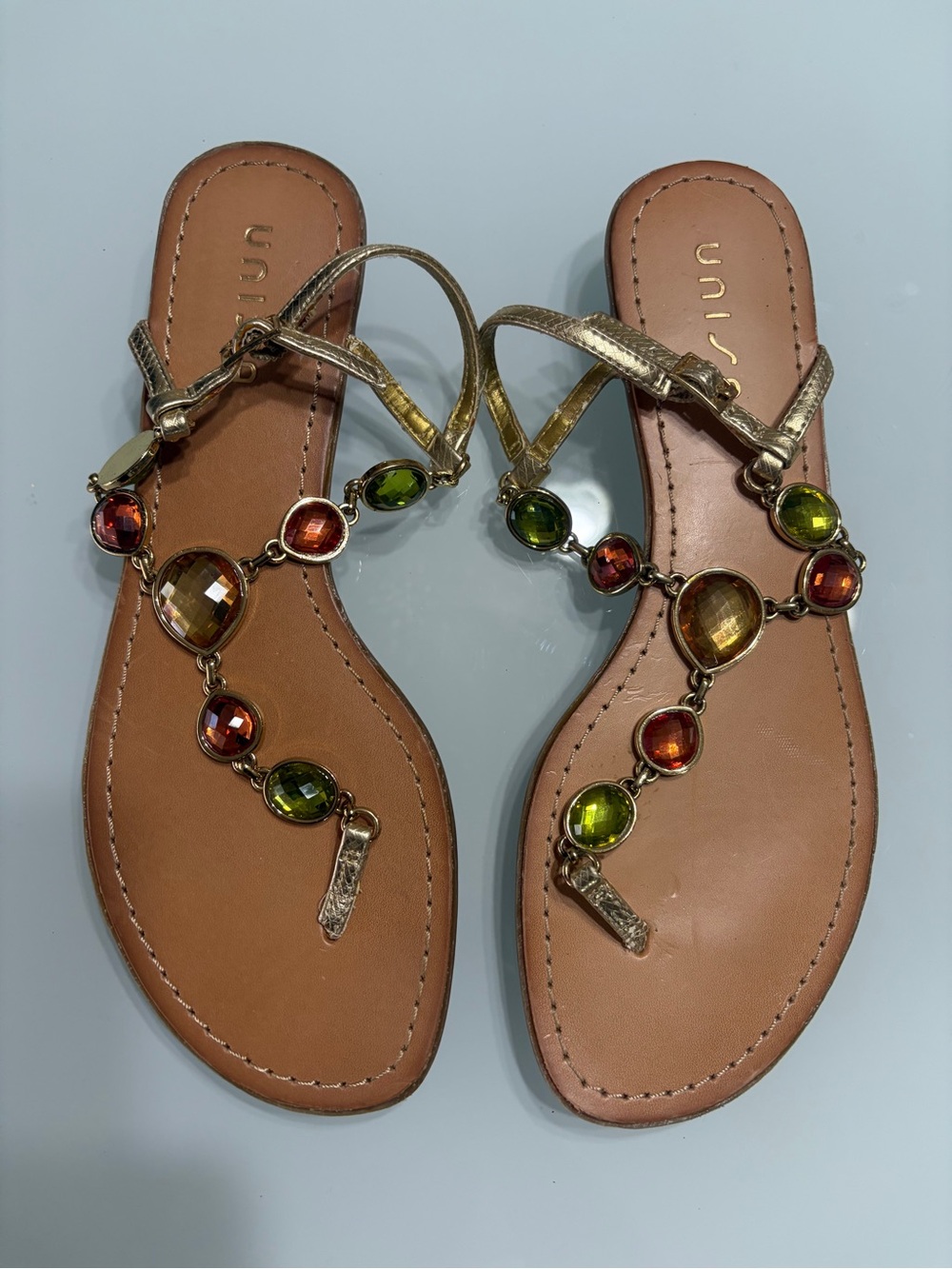Unisa Gold T-Strap Sandals with Green & Amber Gems